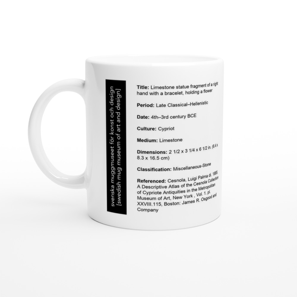 Limestone statue fragment of a right hand with a bracelet, holding a flower — label view